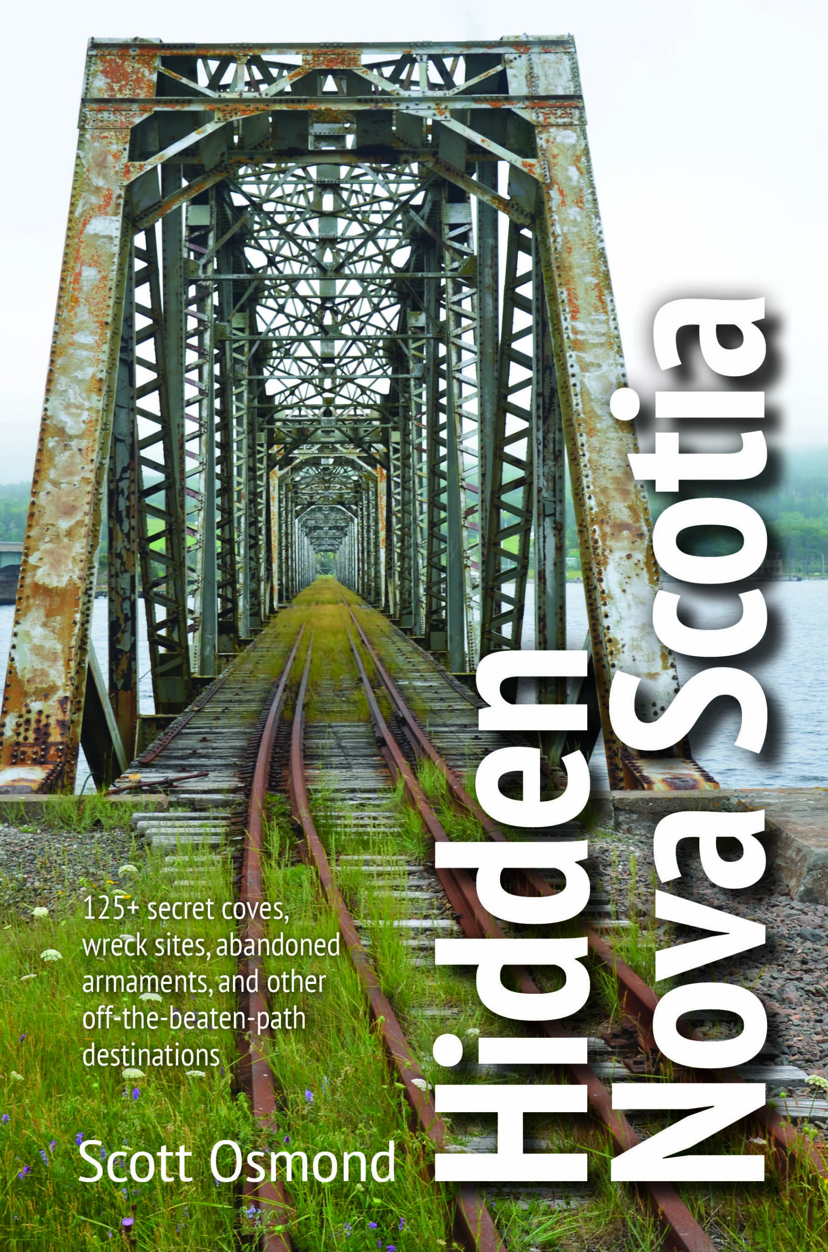 Front cover of Hidden Nova Scotia: 125+ secret coves, wreck sites, abandoned armaments, and other off- the-beaten-path destinations. Title over photo of railway bridge.