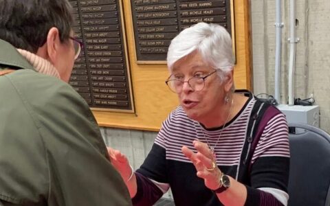 Author Margot Duley speaking with guest at book launch.